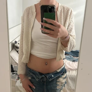 Beige /vit croppad tunn jacka/ kofta med struktur - Säljer en vit/ beige croppad tunn jacka/ kofta med coolt strukturmönster och dragkedja framtill. Jackan har lång ärm och är tillverkad i ett lätt, transparent material som ger en fräsch vibe. Ganska använd då ja fått dem av min mamma som använt den❤️
