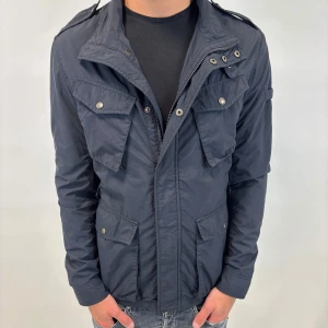 Woolrich Jacka  - Hej! Säljer nu denna väldigt snygga och eftertraktade Woolrich Fieldjacka!  Jackan är slutsåld överallt och går inte att få tag på… jackan är perfekt nu till hösten/vintern  Storlek L fits M Skick 9,5/10  Ny pris: 6000 kr Säljs för: 1999 kr