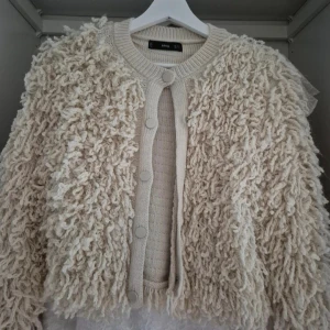 Beige fluffig kofta från MNG - Supermysig beige kofta från MNG, aldrig använd. Koftan är vrm och är stickad i ett tjockare material. Perfekt för dig som vill sticka ut med en unik och trendig look.❤️❤️