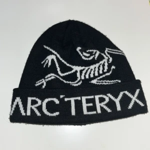 Svart mössa från Arc'teryx - Svart mössa från det välkända och trendiga märket Arc’teryx. Mössan har inga speciella tecken på användning.