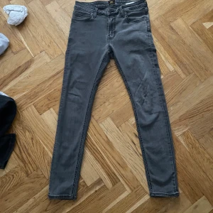 Grå slim jeans från Lee  - Säljer ett par grå skinny jeans från Lee, modell Malone. Jeansen är i nytt skick . 30/30