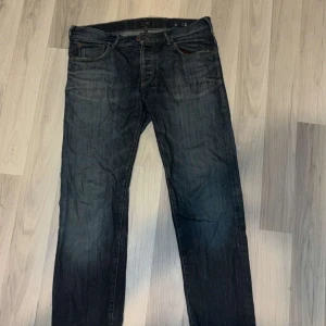 Mörkblå jeans från Armani - Snygga mörkblå jeans från Armani med klassisk femficksdesign och diskret logga på bakfickan. Jeansen har raka ben och normal passform, tillverkade i slitstarkt denimtyg. Perfekta för dig som gillar stilrena och tidlösa jeans.