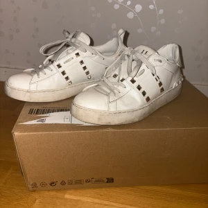 Valentino Garavani vita Rockstud sneakers storlek 39 - Säljer mina äkta Valentino Garavani Rockstud sneakers i storlek 39. Inköpta på Net-a-porter för drygt ett år sedan, nypris 7700. De är använda men i bra skick, håller formen och inga slitage inne i skon. Sulan också i bra skick. Inte små i storleken, mer som 39.5. Har original kartong och extra skosnören 
