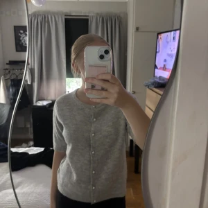 Grå kofta med pärlknappar från 157 - Superfin ljusgrå kofta från 157 med pärlknappar framtill. Superskön och varm. Perfekt att slänga på sig när det är lite kyligt ute men otroligt fin. Använd 1gång därför säljes.