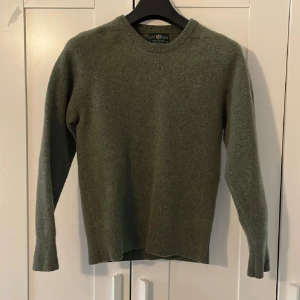 Alan Paine Ulltröja - Klassisk grön stickad tröja från Alan Paine i mjuk ull. Väldigt bra skick men råka krympa i tvätten och är nu i storleken 158/164 barn skulle jag estimera. Priset kan diskuteras vid snabb affär. 