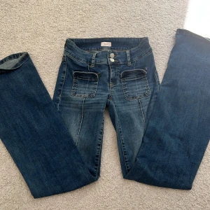 Low waist Bootcut jeans med fickor från Nelly - Snygga blå bootcut jeans från Nelly med låg midja och markerade sömmar framtill. Jeansen har stora fickor fram och klassiska bakfickor. Tillverkade i jeansmaterial med en cool tvättad look och dubbla knappar i midjan. Finns inte längre i Nellys sprtement men köptes för 600kr 👖