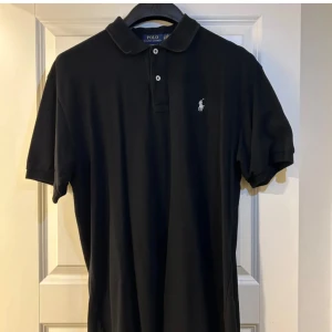 Svart pikétröja från Ralph Lauren - Säljer en snygg svart pikétröja från Polo Ralph Lauren. XXL men passar XL. Skriv vid minsta fundering. Skicka prisförslag och pris går att diskuteras! :) Skriv för flera och detaljerade bilder! 