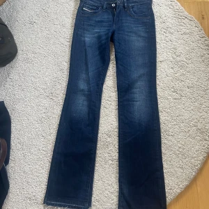 Diesel jeans i nyskick - Ett par Diesel jeans i nyskick. Lågmidjade. Kolla annonsen för storleken, men skulle säga ca XS och passar mig perfekt i längden som är 170, Bootcut modell. Jeansen är sprättade längst ned! Nypris är 1500 kr.