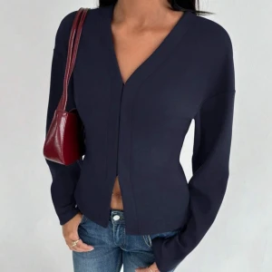 Mörkblå v-ringad kofta - Pris kan diskuteras❤️Snygg mörkblå kofta med v-ringning och lång ärm. Modellen är figurnära med en stilren design utan synliga knappar eller dragkedja. Perfekt att matcha med jeans för en clean look.