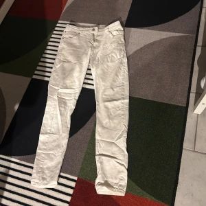 Vita jeans från Studio Total - Snygga vita jeans från Studio Total med klassisk femficksdesign och raka ben. Byxorna har normal passform och är tillverkade i ett mjukt bomullstyg som känns skönt mot huden. Perfekta för dig som vill ha en clean och stilren look.