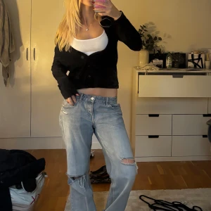 Svart kofta st tropez - Svart croppad kofta med lång ärm och knäppning framtill. Enkel och stilren design som passar perfekt till jeans eller kjol. Koftan har en normal passform och är tillverkad i ett mjukt material som känns skönt mot huden.