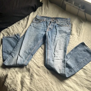 Nudie Jeans - Säljer dessa blå jeans från Nudie Jeans med snygga slitna detaljer vid bensluten. Storlek:       W 31 L34 | skick: 7/10 några få slitningar. Vid minsta fråga elelr fundering är det bara höra av sig🫡🤗
