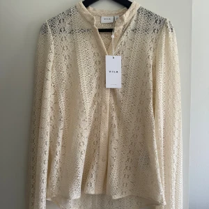 Oanvänd krämvit spetsblus! - Superfin krämvit spetsblus från VILA! Aldrig använd och med lappen kvar! Storlek XS men passar även mig som är S! Nypris 420 kr