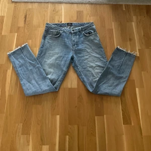 Ljusblå jeans från neuw Stockholm Ray Straight - Ljusblå raka jeans från neuw Stockholm, modell Ray Straight. Klassisk femficksdesign, normal passform och råa, fransiga benslut för en avslappnad vibe. Tillverkade i bomullsdenim med snygg tvättad look