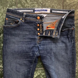 Jacob cohën Nick - Jacob cohën mörkblå Modell nick. Inga defekter förutom att storleks lappen är bort klippt, modellen är 180,75 kg och passar perfekt på honom. Mått A: 42 cm B: 104 cm. Kom med frågor! Upplevs som W32,L32. Ta dina egna jeans och jämför med måtten! 🫶