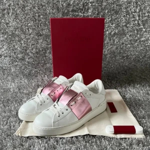 Valentino Open sneakers vit/rosa metallic - Snygga Valentino Open sneakers bilden är tagen från när jag köpte dom här på Plick men dom är knappt använda så bara att skriva om ni vill ha fler bilder ifrån mig🤗dust bag och låda o allt tillkommer💞