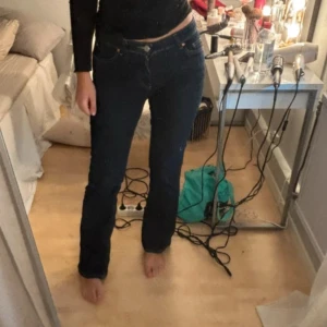 Mörkblå bootcut jeans  - Snygga mörkblå jeans med klassisk femficksdesign och bootcut-ben. Jeansen har låg midja och raka sömmar, tillverkade i robust denim som sitter riktigt bra. Perfekta för dig som gillar en tidlös och clean look.