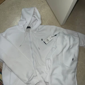 vit Polo Ralph Lauren set  - ‼️‼️pris kan diskuteras ‼️‼️Vit hoodie från Polo Ralph Lauren med dragkedja framtill och klassisk huva med snörning. Passar xl och L Tröjan har den ikoniska broderade loggan på bröstet och är tillverkad i mjukt bomullsmaterial. Perfekt för en clean och stilren look. 