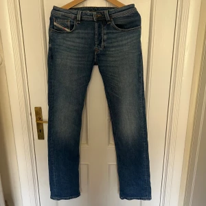 Diesel Larkee blå jeans W29 L32 - Säljer ett par klassiska blå jeans från Diesel, modell Larkee. Jeansen har raka ben, normal passform och snygga detaljer på bakfickorna. Perfekta för dig som gillar en tidlös stil. Endast använda ett fåtal gånger så är i superskick! Mitt pris 699kr, nypris 1500kr. Det är bara att skriva om du har frågor eller fler bilder!😎😊