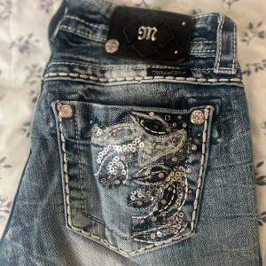 Miss me bootcut jeans storlek 25 -  Säljer mina true religion jeans eftersom de inte passar min still längre så de har använts fåtal gånger. 3 knappar från miss me lappen har ramlat av(kolla bilden.)  Lårvidd: 21 cm Midjemått: 36 cm           Innerbenslängd: 73 cm  