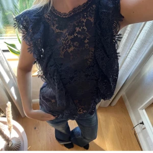 Mörkblå spetsblus med volang - ⚠️INTE MIN BILD ⚠️säljer min supersnygga blus ifrån Zara!! Den är i mycket bra skick och använt ett fåtal gånger. Säljer den då den inte kommer till användning längre ❤️ priset kan diskuteras via snabbaffär❤️