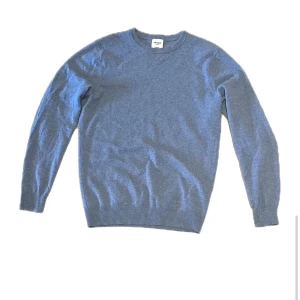 Blå kashmirtröja från John Henric - Mjuk och stilren blå tröja i 100% kashmir från John Henric. Klassisk rund halsringning och ribbade muddar vid ärmslut och nederkant. Perfekt för dig som vill ha en enkel men lyxig look till vardags. Passar dig som gillar en normal passform.