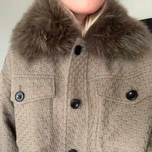 Jacka från Meotine - Jackan är från märket Meotine i en längre modell. Nypris för den korta varianten av samma jacka ligger på ca 5 000 kr, men jag minns tyvärr inte exakt vad jag betalade för denna.  Den är i fint skick och väl omhändertagen – alla knappar är kvar och den är inte nopprig. Jag är 170 cm lång och brukar ha XS/S. Jackan är fodrad och på mig rymlig nog för att bära en tjock tröja eller en tunn väst under.