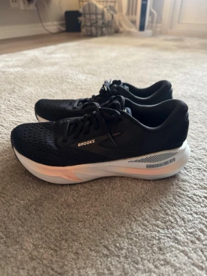 Brooks Adrenaline GTS löparskor svart - Säljer ett par Brooks Adrenaline GTS löparskor i svart med vit. Ovandelen är i ventilerande mesh och skorna har klassisk snörning. Perfekta för löpning eller träning, med bekväm och stabil sula. Säljer dessa då de inte passar mitt löpsteg helt o hållet och är därför endast testade några enstaka gånger. Köpta på Löp & Sko i Göteborg för 1800 kr