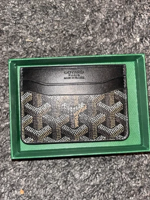 Svart plånbok  - Snygg svart plånbok  med ikoniskt grafiskt mönster i vitt och beige. Tillverkad i skinn och har flera kortfack. Perfekt för dig som vill ha något stilrent och lyxigt i fickan. Fraktas samma dag😁👍