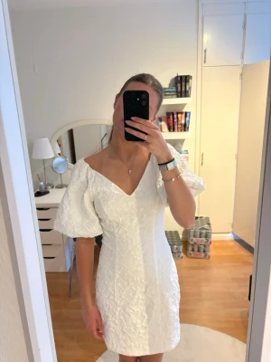 Student klänning!!!! - Superfin vit kort klänning med v-ringning och puffiga korta ärmar. Slutsåld i butik och online! Tänkte ha på studenten men blev en annan så helt oanvänd🌟köpt av en tjej här på plock och hon är 168(sista bilden) och jag är 171cm☺️Materialet ser ni på nästsista bilden💕