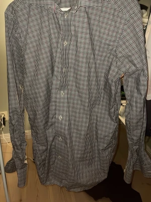 Rutig skjorta från Eton i bomull - Säljer en klassisk rutig skjorta från Eton i bomull. Skjortan har lång ärm, knappar framtill och ett tidlöst rutmönster i blått, grönt och rött. Perfekt för dig som gillar stilrena och snygga skjortor med modern passform.