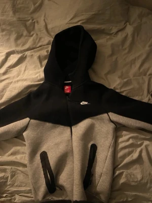 Nike Tech fleece  - Säljer min Nike tech fleece i färgen grå svart då jag inte har användning för den. Tröjan har inga skador eller defekter. Storlek xs passar även s beroende på längd. 