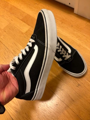 Svarta Vans Old Skool sneakers - Säljer ett par Vans Old Skool i svart/vitt. Skorna är endast använda 1–2 gånger och är i mycket fint skick. Inga skador eller större tecken på användning. Säljs då de tyvärr inte kommer till användning. Hör gärna av dig vid frågor eller om du vill ha fler bilder
