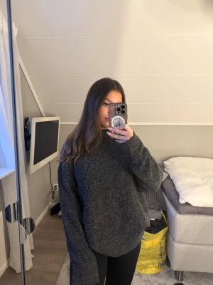 Mörkgrå oversized stickad tröja - Mysig mörkgrå stickad tröja med oversized passform och långa ärmar från Lager 157. Materialet är mjukt och fluffigt, vilket gör den extra bekväm.