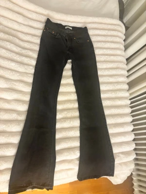 Svarta bootcut jeans från Weekday - Säljer ett par svarta bootcut jeans från Gina tricot. Jeansen har klassisk femficksdesign, kopparfärgade nitar och en snygg utsvängd passform nedtill. Tillverkade i jeansmaterial med midja som sitter bekvämt. Perfekta för en trendig och avslappnad stil.lågmidjade