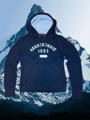 Abercrombie & fitch hoodie XS - Säljer en sjukt snygg och unik Abercrombie hoodie. Den är i bra skick 8/10 och passar storleken XS.