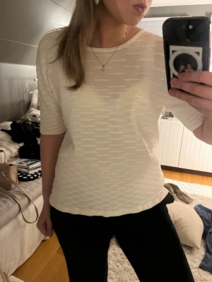 Vit topp - Säljer en vit topp med diskret strukturmönster och rund hals. Toppen har halvkort ärm. Den är köpt second hand och saknar lapp så vet tyvärr varken var den är ifrån eller vilken storlek, skulle uppskatta s/m. Hör av dig vid frågor😅