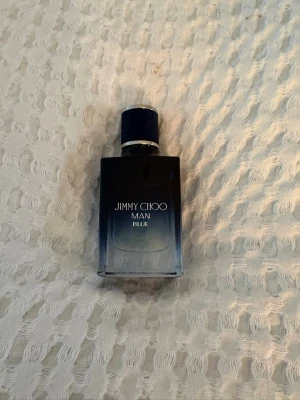 Jimmy Choo Man Blue parfym 30 ml - Snygg parfymflaska från Jimmy Choo, Man Blue. Flaskan är i glas med en snygg blå gradient och silverdetaljer. Rymmer 30 ml och har en stilren, modern design som passar perfekt i badrumshyllan.