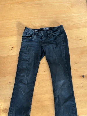 Svarta straight jeans från LTB - Säljer ett par svarta jeans från LTB med klassisk femficksmodell och raka ben. Jeansen har diskreta slitningar på framsidan för en cool look. Perfekta till vardags och passar till det mesta.