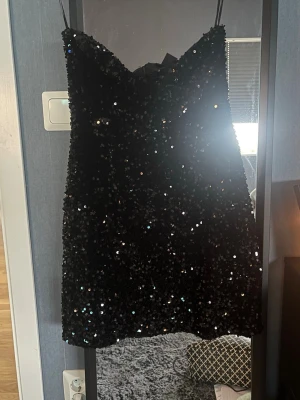 Svart glittrig paljettklänning  - En kort svart glitter klänning som bara används en gång.