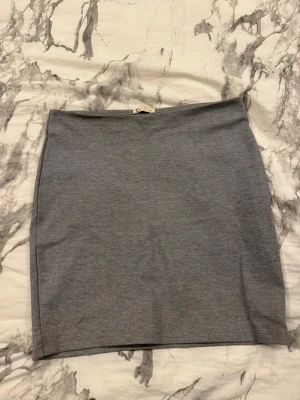 Grå kortkjol från Cubus - Enkel och stilren grå kortkjol från Cubus i storlek S. Kjolen har en rak passform och är gjord i ett mjukt och stretchigt bomullsmaterial. Perfekt att matcha med en crop top eller hoodie för en chill look.