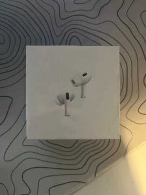 AirPods Pro (2nd Generation) with MagSafe Charging Case (USB-C) - Helt nya Apple AirPods Pro (2nd Gen) med MagSafe-laddningsetui (USB-C). Oöppnad originalförpackning. Aktiv brusreducering, adaptiv EQ och transparensläge för bästa ljudupplevelse. Perfekt för både iPhone och andra Apple-enheter.