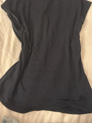 Topp - En enkel marinblå topp från 157 i storlek XS. Modellen har korta ärmar och rak passform. Tillverkad i mjuk bomull som känns skön mot huden. Perfekt att matcha med jeans eller kjol för en clean look.