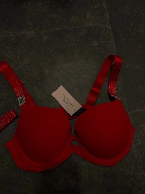 Röd bh med strass från Victoria's Secret - BH storlek 75B. Trosorna storlek M men nassar även S. Fick som julklapp men inte rätt storlek🩷 Båda delarna är med prislapp