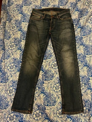 Blå Nudie Jeans - Snygga blå slim/straight jeans från Nudie i modellen Grim Tim. Färgen är faded memory. Inköpta i butik i somras för 1600, storlek 31/30