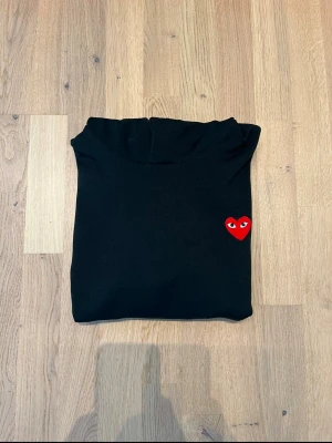Play hoodie från Comme des Garçons - Säljer min svarta Play Hoddie från Comme des Garçons. Den är i storlek S och jag säljer den för att den blivit för liten. Skicket är mycket fint! Tveka inte på att höra av dig vid frågor😃 Bvsa 
