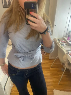 randig blus med knut - blåvitt randig blus med knut på framsidan. trekvartsärmad.