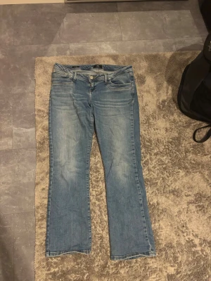 Blå bootcut jeans från LTB Valerie - Snygga ljusblå jeans från LTB, modell Valerie. Klassisk femficksdesign med bootcut-ben och normal passform. Jeansen har dragkedja och knapp framtill samt subtila slitningar för en avslappnad look. Perfekta till sneakers eller boots.