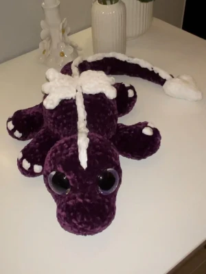 Lila drake med vita detaljer💜🤍🐉 - Är det dig denna drake kommer hitta sitt för alltid hem hos?💜🤍🐉 Denna är virkad med kärlek, jag älskar att virka och kul att göra nån annan glad av slutprodukten✨🥰 Den är virkad av mjukt garn från Rusta, hårda ögon som inte går att ta av (lila ögon). Den är 54 lång och man sträcker ut svansen🐉
