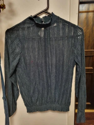 Grön glittrig turtleneck blus - Elegant skimrande mörkgrön turtleneck från märket pieces